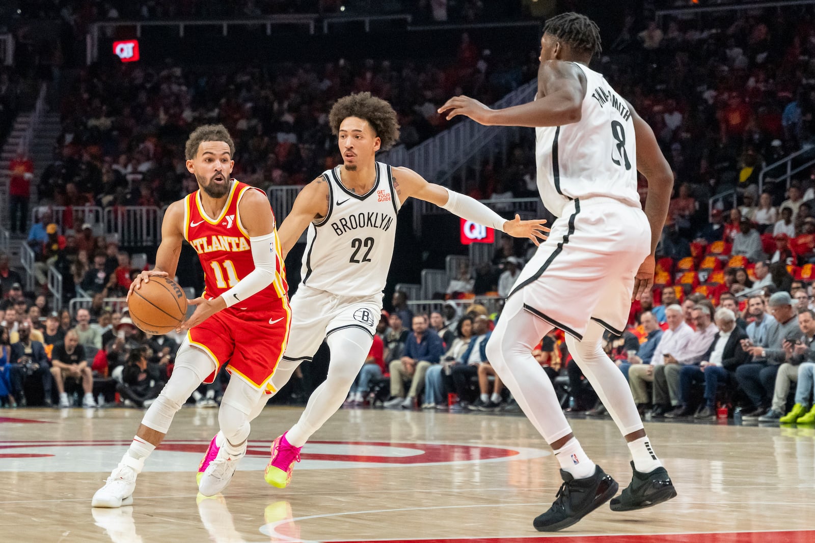 Atlanta Hawks guard Trae Young (11) drives the lane guarded by Brooklyn Nets forward Jalen Wilson (22) and forward Dorian Finney-Smith (28) during the first half of an NBA basketball Wednesday, Oct. 23, 2024, in Atlanta. (AP Photo/Jason Allen)