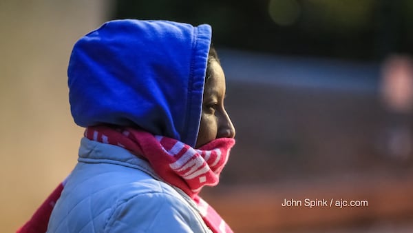 Candlaria Bibiano waits for her bus at the North Avenue MARTA station on a chilly and windy Monday morning. JOHN SPINK / JSPINK@AJC.COM