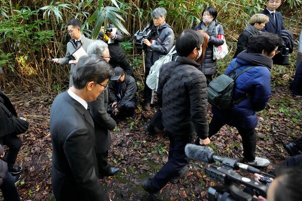 South Korean Ambassador to Japan Park Cheol-hee, left, walks with the relatives of Korean victims and South Korean officials to hold a memorial service at the site of former Fourth Souai Dormitory for the mine workers from the Korean Peninsula, in Sado, Niigata prefecture, Japan, Monday, Nov. 25, 2024, after boycotting a memorial organized by Japanese officials. (AP Photo/Eugene Hoshiko)