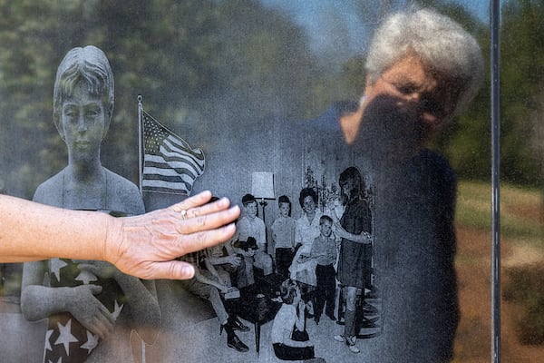 Margo Truett touches an image of her family engraved at the Dignity Memorial Vietnam Wall at the National Infantry Museum in Columbus.