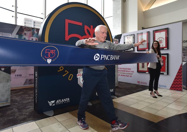 February 15, 2019 Atlanta - Bill Thorn, the only person to complete every running of the Peachtree, poses for a ceremonial finish line photograph during an unveiling event of traveling display at Lenox Square on Friday, February 15, 2019. Atlanta Track Club unveiled a traveling display detailing the history, legends and legacy of the worldâs largest 10K just feet from the Peachtree start line inside Lenox Square on Friday, February 15, 2019 at 10 a.m. HYOSUB SHIN / HSHIN@AJC.COM