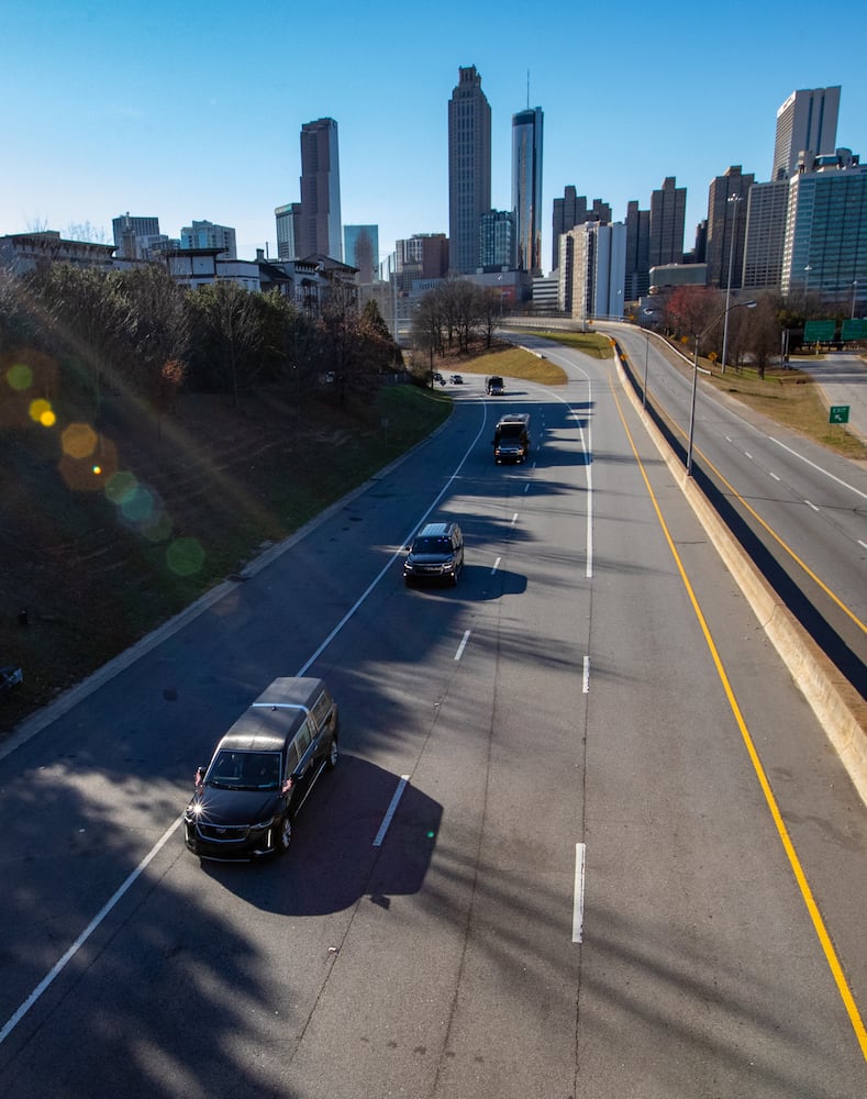 The body of Jimmy Carter, in front vehicle, is carried from the Georgia Capitol to the Carter Center on Freedom Parkway under the Jackson Street Bridge on Saturday, Jan 4, 2025.  (Jenni Girtman for The Atlanta Journal-Constitution)