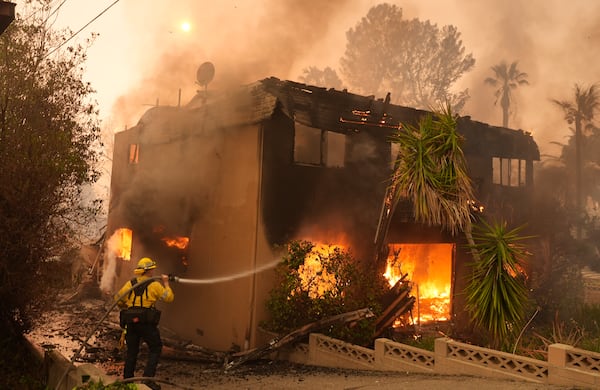 FILE - A firefighter tries to extinguish flames at a burning apartment building during the Eaton Fire, Jan. 8, 2025, in Altadena, Calif. (AP Photo/Chris Pizzello, File)