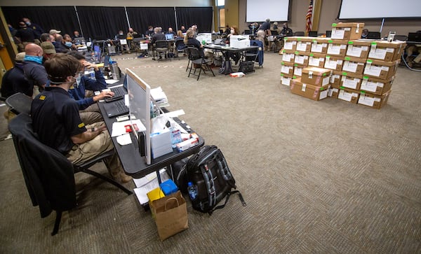 GBI agents audit absentee ballot signatures last week at the Cobb County Civic Center. STEVE SCHAEFER FOR THE ATLANTA JOURNAL-CONSTITUTION