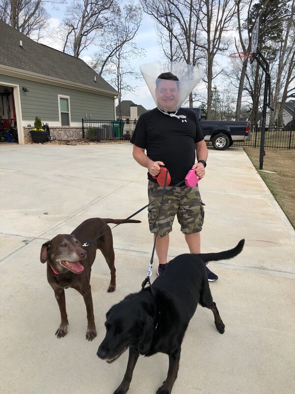 My dogs Baxlee (left) and Watson thought it was hilarious that I put on Baxlee's protective cone for one of our umpteen walks around the neighborhood during this shelter-in-place season. (Photo by Chip Towers/ctowers@ajc.com)