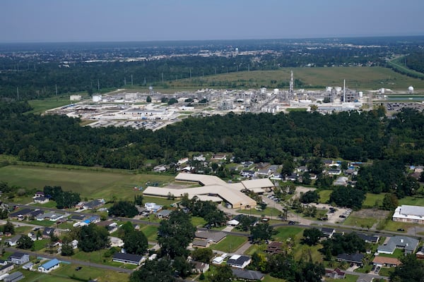 FILE - The Fifth Ward Elementary School and residential neighborhoods sit near the Denka Performance Elastomer Plant, back, in Reserve, La., Sept. 23, 2022. (AP Photo/Gerald Herbert, File)