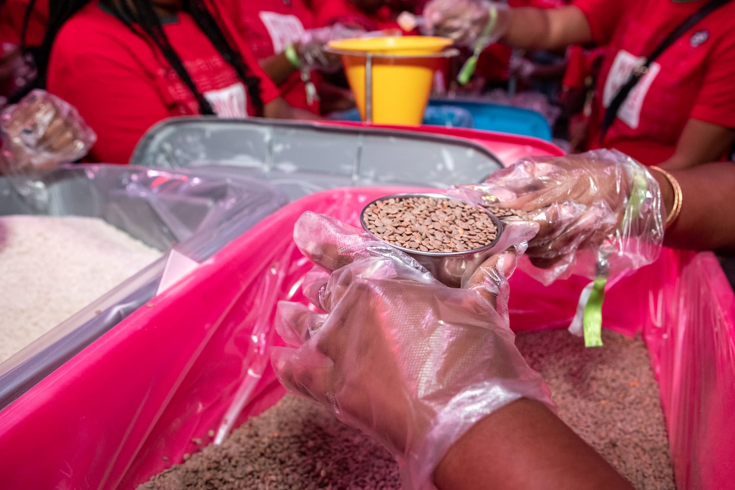 Volunteers pack red lentil jambalaya kits for local food banks. (Jenni Girtman for The Atlanta Journal-Constitution)