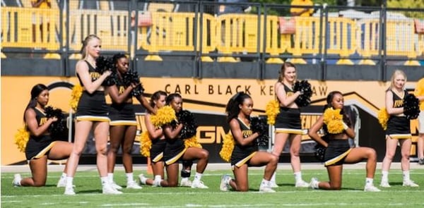 Some Kennesaw State University cheerleaders take a knee during the national anthem before the football game Sept. 30, to protest police misconduct and racial inequality. (Cory Hancock)