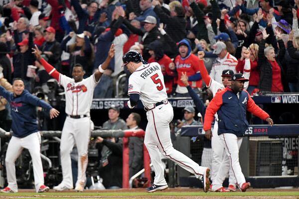 Braves players and fans react after Atlanta Braves first baseman Freddie Freeman (5) hit a solo home run to put the Braves up 5-4 during the third inning against the Houston Astros in game 5 of the World Series at Truist Park, Sunday October 31, 2021, in Atlanta. Hyosub Shin / Hyosub.Shin@ajc.com