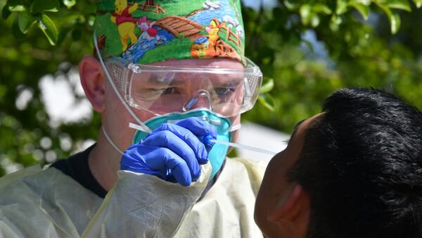 A medical professional collects a nasal swab from a potential COVID-19 patient who walked in at a drive-through COVID-19 testing site at Good News Clinic in Gainesville, Georgia, on April 28, 2020. Northeast Georgia Health System partnered with Good News Clinic to test more than 300 Hall County adults and children for COVID-19. (Hyosub Shin / Hyosub.Shin@ajc.com)