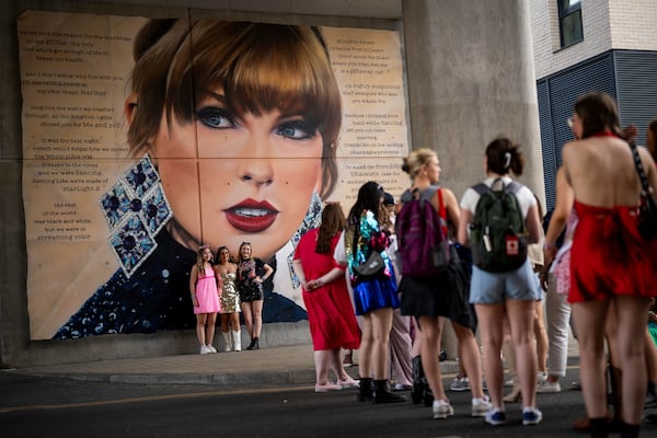 FILE - Taylor Swift fans pose in front of a mural before attending Swift's concert on June 21, 2024 in London. (Photo by Scott A Garfitt/Invision/AP, File)