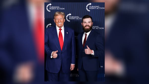 Orien Roy, right, gives a "thumbs up" while posing with former President Donald Trump.