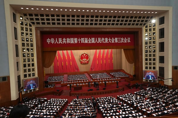 Chinese President Xi Jinping is displayed on screens during the opening session of the National People's Congress (NPC) at the Great Hall of the People in Beijing, China, Wednesday, March 5, 2025. (AP Photo/Ng Han Guan)