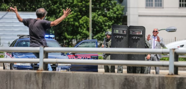 Atlanta police detective Vince Velazquez talks a man out of jumping from a bridge on July 7, 2016. There were no injuries and the incident ended peacefully.  JOHN SPINK /JSPINK@AJC.COM