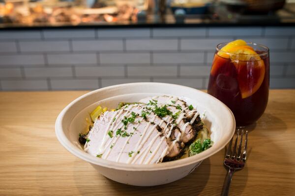  The signature Pork and Grits bowl, with rainbow chard, cheddar grits, corn, pickled red onion and okra, and molho sauce./Photo credit- Mia Yakel.