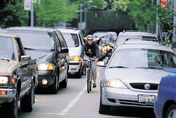 Both drivers and bicycle riders need to know the laws and be aware of each other to prevent accidents. Bike messenger Caitlin McElroy is shown in this file photo. (Seattle Times)