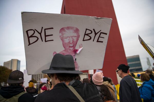 11/08/2019 -- Atlanta, Georgia -- An anti-Trump protestor holds a protest sign during a rally outside of the Georgia World Congress Center in downtown Atlanta, Friday, November 8, 2019. President Trump was in Atlanta on Friday to speak to a crowd of African American voters that support his presidency. (Alyssa Pointer/Atlanta Journal Constitution)