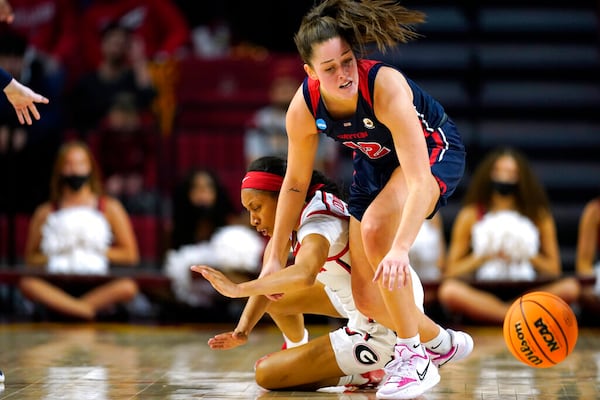 Georgia guard Mikayla Coombs, left, fights for a loose ball with Dayton guard Jenna Giacone (12) during the second half of a first round game in the NCAA women's college basketball tournament, Friday, March 18, 2022, in Ames, Iowa. Georgia won 70-54. (AP Photo/Charlie Neibergall)