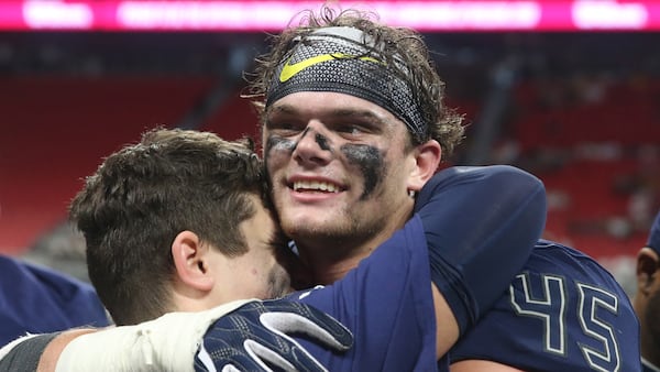  Eagle's Landing Christian defensive end Harrison Taylor (45) and a teammate celebrate their win over Athens Academy in the Class A Private Championship. (Jason Getz/For the AJC)