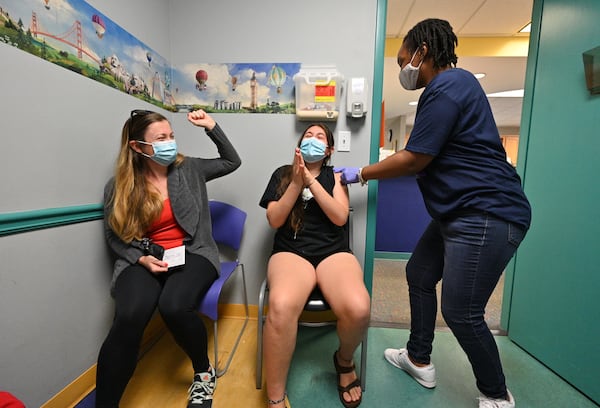 May 12, 2021 Decatur - Lucy Saravia, 13, and her mother Robin Mead (left) celebrate after Lucy received a first dose of the Pfizer-BioNTech vaccine from Pheona Mack (right), RMA, at Dekalb Pediatric Center on Wednesday, May 12, 2021. More than a thousand patients, most of them 12-15 years old, had seized the opportunity to get a shot of the Pfizer-BioNTech vaccine at the clinic, which is partnering with the local school system to vaccinate students. (Hyosub Shin / Hyosub.Shin@ajc.com)