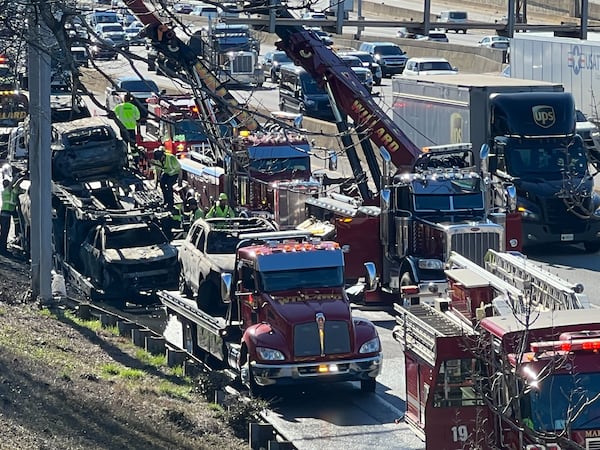 Cranes start to remove individual cars from the car carrier after the fire.