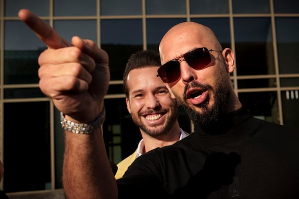 FILE - Andrew Tate gestures, next to his brother Tristan, outside the Bucharest Tribunal in Bucharest, Romania, Thursday, Jan. 9, 2025. (AP Photo/Vadim Ghirda)