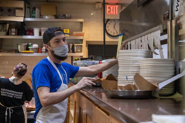 Sous chef Charlie Zaremba calls orders to the line cooks during the lunch rush at Muss & Turner’s restaurant in Smyrna. Restaurants are facing a hiring crunch in Georgia and around the nation.   (Alyssa Pointer/Atlanta Journal Constitution)