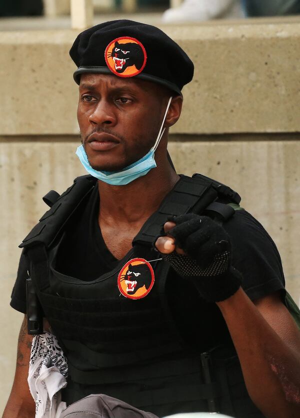 An unidentified member of a group of young creatives posing as Black Panthers takes a knee in silence for eight minutes and 46 seconds in Decatur Square on Wednesday, June 3, 2020, in Decatur, Georgia. One of the group’s leaders said he chose the outfit to inspire protesters. CHRISTINA MATACOTTA FOR THE AJC