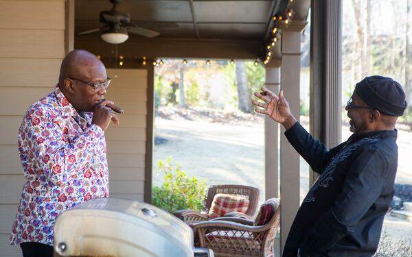 Siblings John Taylor (right) and Lewis Thompson smoke a cigar  together during a family reunion on Wednesday, December 27, 2022, in Suwanee. At the event, 62-year-old Thompson, visiting from Australia, met four of his seven biological siblings for the first time. CHRISTINA MATACOTTA FOR THE ATLANTA JOURNAL-CONSTITUTION. 