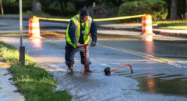 A DeKalb County Watershed Management worker begins shutting off water after Monday's break.