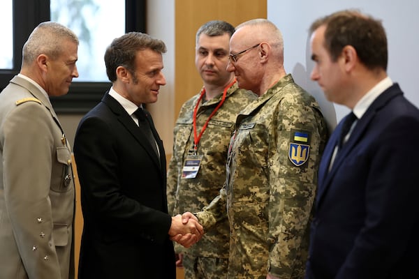 French President Emmanuel Macron, second left, , shakes hands with Colonel-General Ruslan Khomchak, First Deputy Secretary of the National Security and Defense Council of Ukraine, as French Defense Minister Sebastien Lecornu, right, and Chief of Staff of the French Armed Forces Thierry Burkhard, left, look on during a meeting on the conflict in Ukraine at the Musee de la Marine as part of the Paris Defense and Strategy Forum in Paris, Tuesday, March 11, 2025. (Sarah Meyssonnier/Pool via AP)