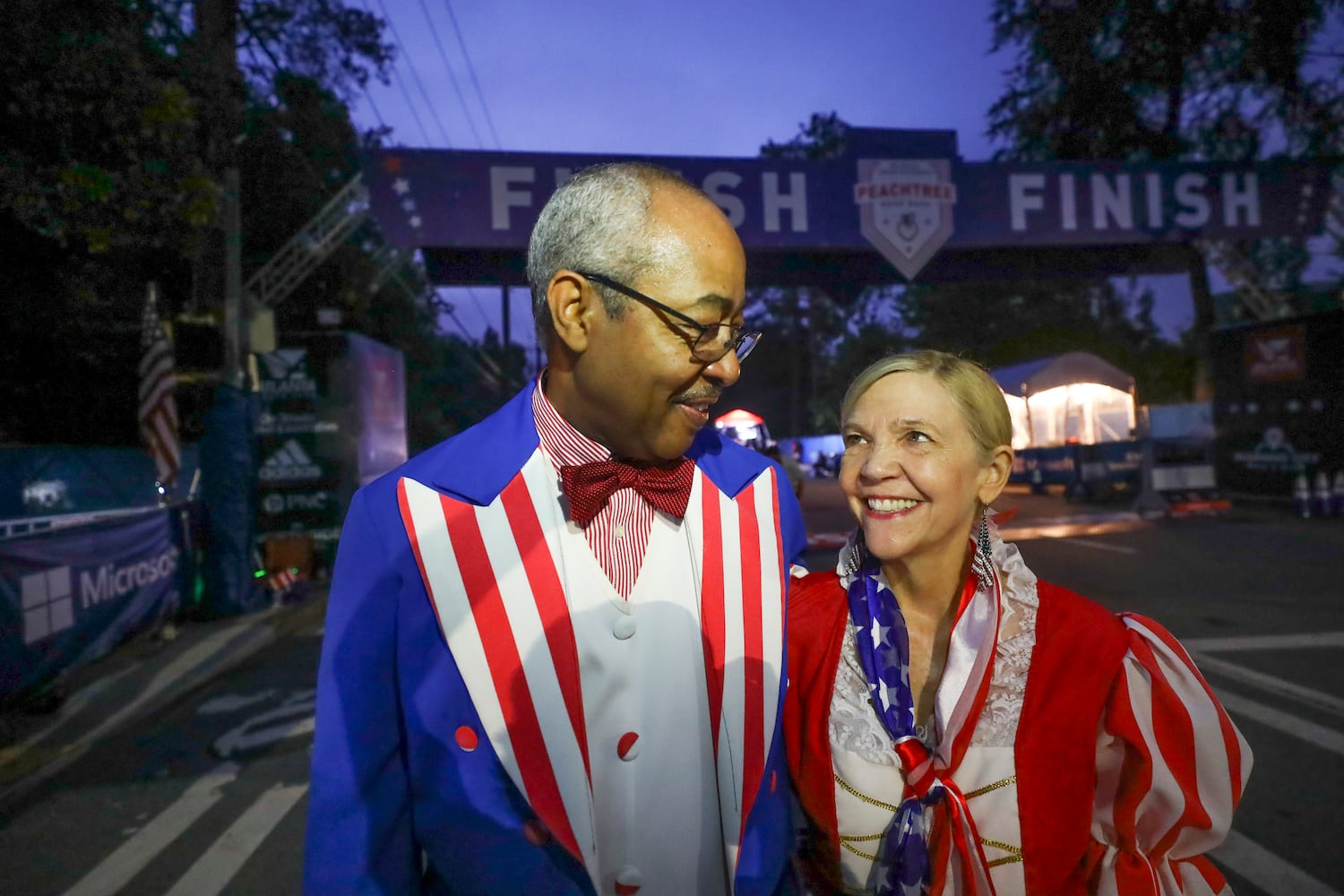 Reg and Paula Barnes are dressed as Uncle Sam and Betsy Ross arrive to staff the finish line at the 53rd running of the Atlanta Journal-Constitution Peachtree Road Race in Atlanta on Monday, July 4, 2022. (Curtis Compton / Curtis.Compton@ajc.com)