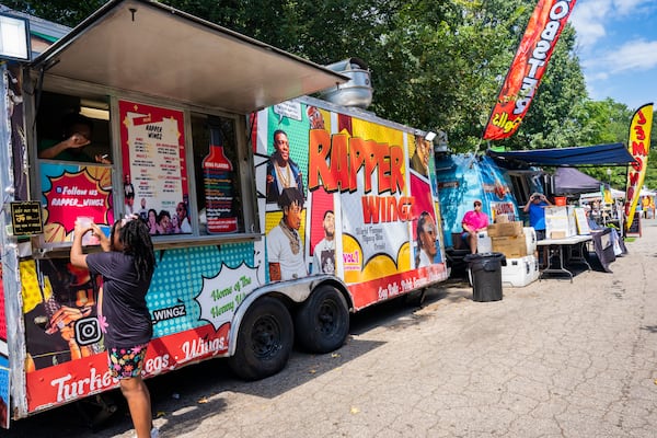 Rapper Wingz sells food at the Pure Heat Community Festival in Piedmont Park on Sunday, Sept. 1, 2024.  (Olivia Bowdoin for the AJC). 