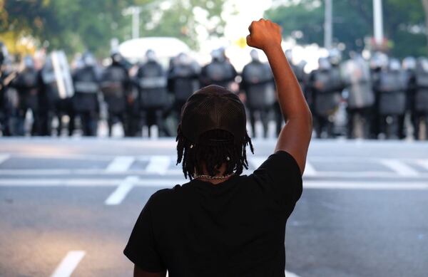 A lone protester faces off with police Monday.