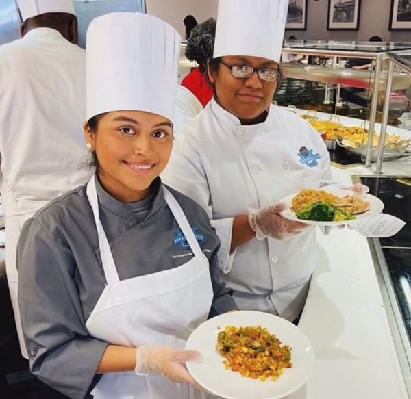 Evelin Castro Lozano (left) poses with fellow Navigate student Jennifer Reano (right) during a shadow day at the Coca-Cola Co. headquarters on Dec. 3, 2019. (Courtesy of Evelin Castro Lozano)