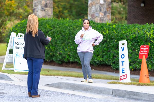 A woman has her photo taken after exiting the polling station, Thursday, Oct. 31, 2024, in Stockbridge, Ga. (AP Photo/Jason Allen)