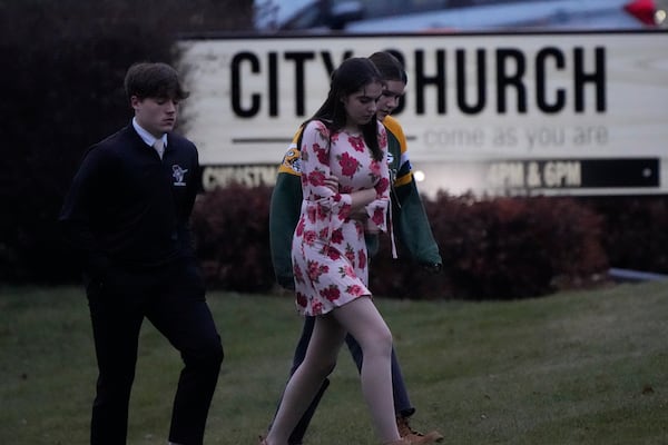 Students walks to a bus as they leave the shelter following a shooting at the Abundant Life Christian School, Monday, Dec. 16, 2024. (AP Photo/Morry Gash)