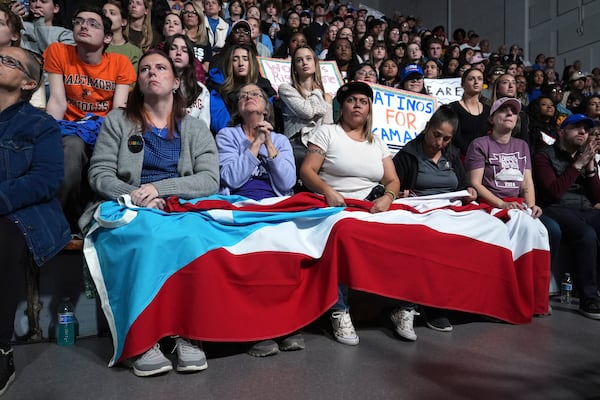 Attendees holding the flag of Puerto Rico listen as Allentown, Pa. Mayor Matt Tuerk speaks during a campaign rally for Democratic presidential nominee Vice President Kamala Harris in Memorial Hall at Muhlenberg College in Allentown, Pa., Monday, Nov. 4, 2024. (AP Photo/Susan Walsh)