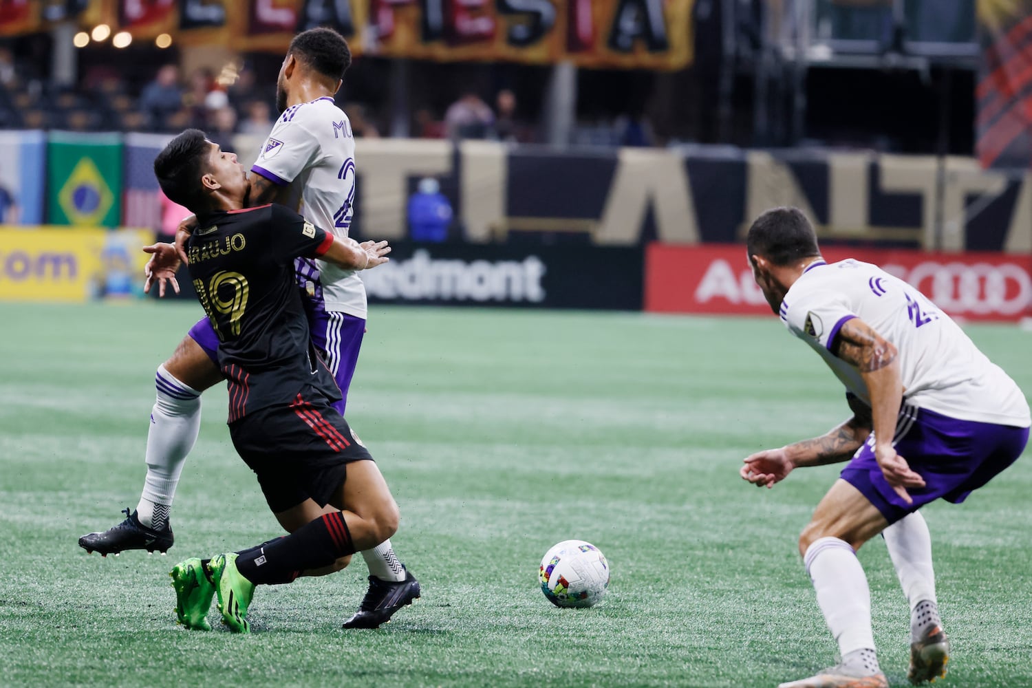 Atlanta United's Luiz Araujo (9) crashes into Orlando's Jake Mulraney during the first half of an MLS game Sunday at Mercedes-Benz Stadium. (Miguel Martinez /Miguel.martinezjimenez@ajc.com)