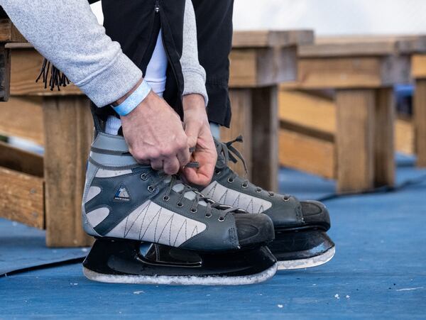 Dan Maier, who lives in South Florida but was in town to visit family, laces up his skates before hitting the ice at the Have an Ice Day rink in downtown Sugar Hill on Saturday afternoon, December 26, 2020. (Photo: Ben Gray for The Atlanta Journal-Constitution)