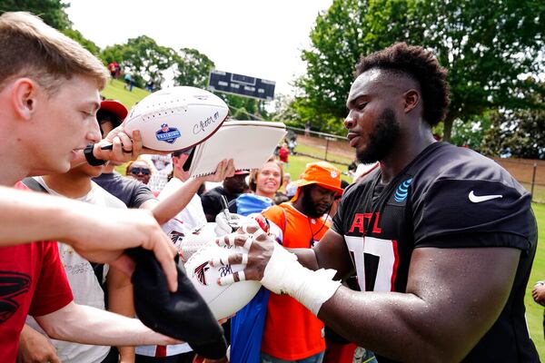 Atlanta Falcons defensive tackle Grady Jarrett signs autographs during the NFL football team's practice on Saturday, July 30, 2022, in Flowery Branch, Ga. (AP Photo/Brynn Anderson)