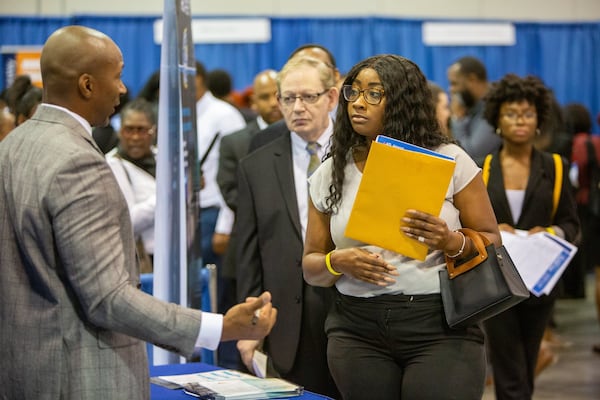 FBI Special Agent Charles Orgbon Jr. (left), working as a recruiter, talks with Desiree Harvey-Lovell during the Hartsfield-Jackson International Airport job fair at the Georgia International Convention Center on October 8, 2019. (Photo by Phil Skinner for the AJC)