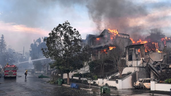 Los Angeles Fire Department firefighters work to extinguish a house fire as the Palisades Fire ravages a neighborhood amid high winds in the Pacific Palisades neighborhood of Los Angeles, Wednesday, Jan. 8, 2025. (AP Photo/Damian Dovarganes)