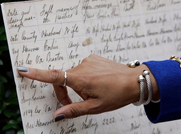 Virginia Secretary of Administration, Viola Baskerville, points out court records that were used to help trace her geneology after a press conference in front of the Black History Museum and Cultural Center of Virginia in Richmond, Va., Thursday, July 9, 2009.  Gov. Tim Kaine announced the online availability of the Virginia Freedman's Board records. Steve Helber/AP