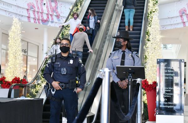 Atlanta police officer and private security officer monitor shoppers at Lenox Square on Tuesday, Dec. 29, 2020. Lenox Square, in the heart of Buckhead, was the site of numerous shooting incidents that year. The Atlanta Police Department has a mini-precinct inside the mall, which has increased security in recent months.  (Hyosub Shin / Hyosub.Shin@ajc.com)