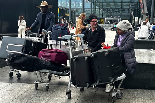 Travellers wait outside the Terminal as Heathrow Airport slowly resumes flights after a fire cut power to Europe's busiest airport in London, Saturday, March 22, 2025.(AP Photo/Kirsty Wigglesworth)