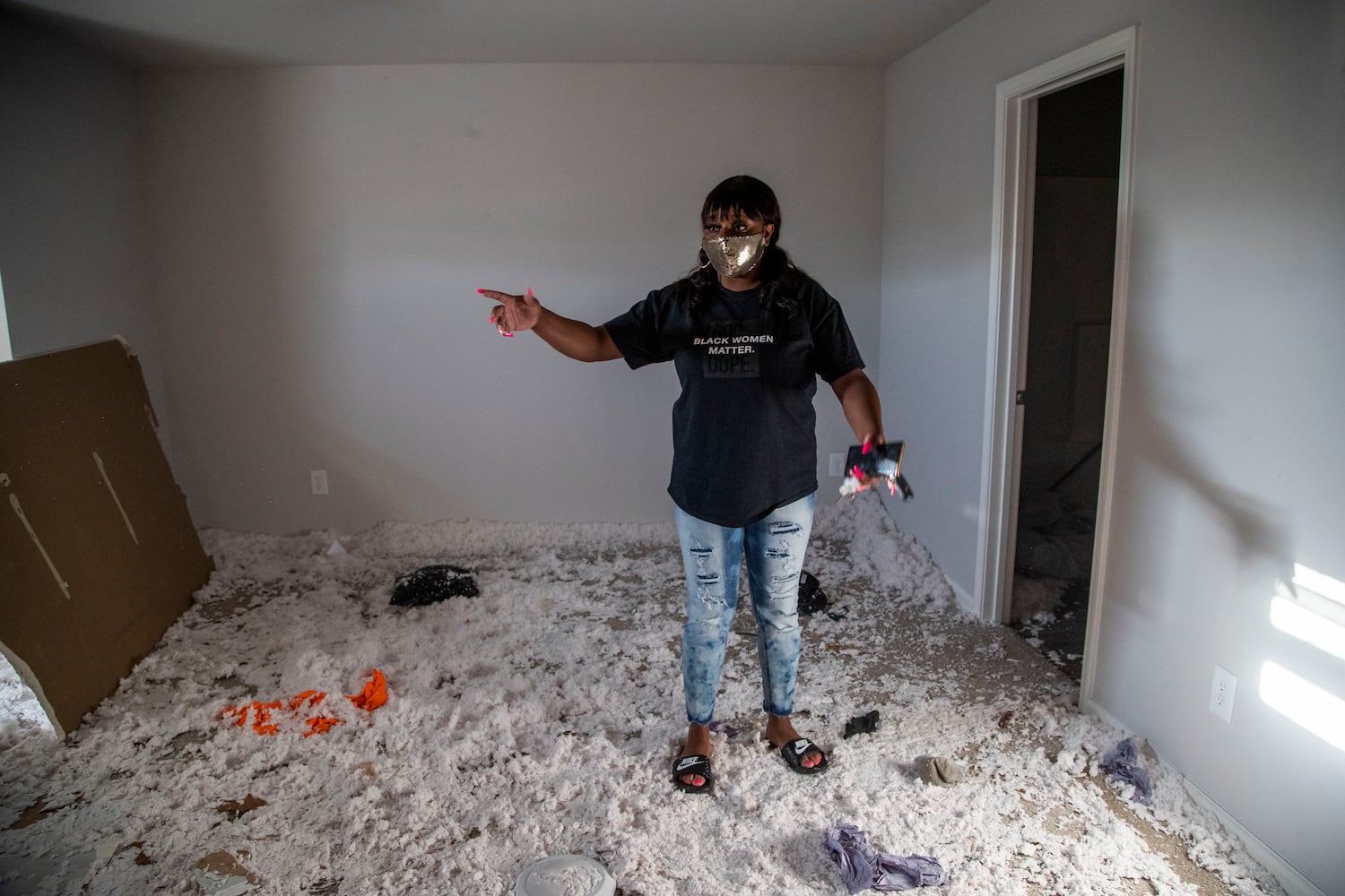 Brittany Mitchell shows where the ceiling caved in within her master bedroom. Brittany was crouched in a hallway closet, using her body to shelter her daughters alongside her husband, when a tornado damaged their home. (Alyssa Pointer / Alyssa.Pointer@ajc.com)