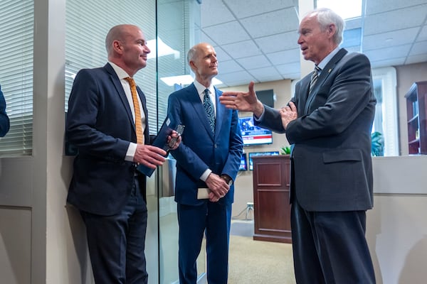 (Left to right): U.S. Sens. Mike Lee of Utah, Rick Scott of Florida and Ron Johnson of Wisconsin confer Wednesday before joining other conservative Republicans to complain to reporters about the interim spending bill being crafted.