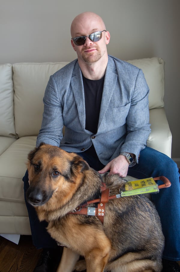 Portrait of Chad Foster with his service dog, Sarge, in his Marietta home. He is a blind man who is a successful business person, who skis downhill and who recently gave a motivational speech at his graduation from Harvard Business School’s leadership program. (Phil Skinner for The Atlanta Journal-Constitution)