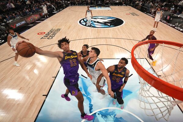 Los Angeles Lakers guard Max Christie (12) reaches for a rebound against Minnesota Timberwolves center Luka Garza (55) during the second half of an NBA basketball game, Monday, Dec. 2, 2024, in Minneapolis. (AP Photo/Abbie Parr)